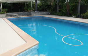 cap 1 - fibreglass lined pool recoated with Pacific Blue and old pebble deck (coping) resurfaced with Riversand