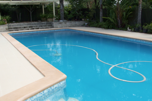 cap 1 - fibreglass lined pool recoated with Pacific Blue and old pebble deck (coping) resurfaced with Riversand